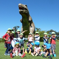 恐竜の像の前で集合写真