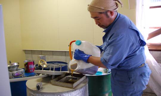 タンクに使用済みの天ぷら油を注ぎ込んでいる様子の写真