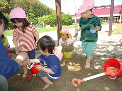 子どもたちが園庭で遊んでいる写真
